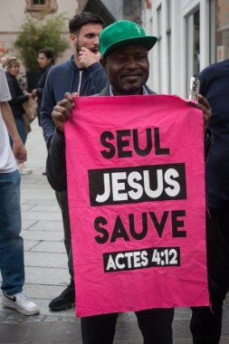 Mulhouse - Fransa - 1 Haziran 2024 - Sokakta elinde levhayla dikilen siyah adamın portresi: Seul İsa Sauve, İngilizce traduction: