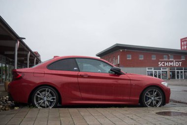 Mulhouse - Fransa - 4 Haziran 2024 - Yağmurlu bir günde sokağa park edilen kırmızı BMW M240I 'nin profil görüntüsü