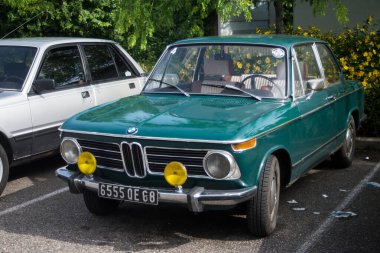 Mulhouse - Fransa - 9 Haziran 2024 - Caddeye park etmiş eski model bir BMW 'nin ön görüntüsü 