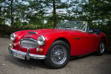 Mulhouse - Fransa - 9 Haziran 2024 - Üstü açık Red Austin Healey arabasının caddeye park edilmiş görüntüsü