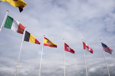 Bulutlu gökyüzü arkaplanındaki uluslararası bayrakların görünümü 