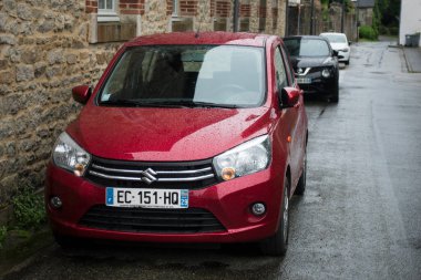 Quimper - Fransa - 10 Temmuz 2024 - Caddeye park etmiş kırmızı Suzuki Swift 'in ön görüntüsü