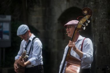 Concarneau - Fransa - 13 Temmuz 2024 - Sokakta kaçak gitar çalan iki müzisyenin portresi