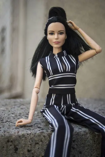 stock image Mulhouse - France - 21 August 2024 -  Portrait of brunette barbie doll wearing a stripped clothes standing in the street