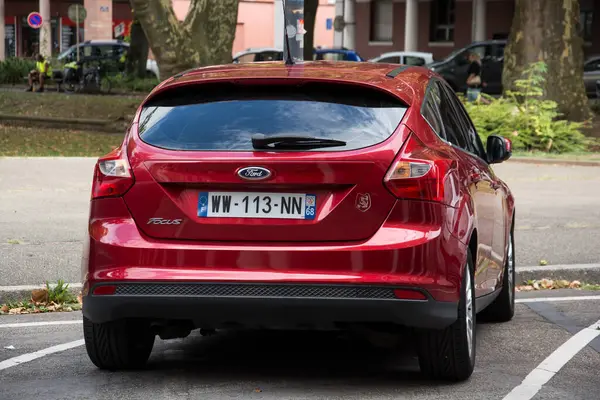 Mulhouse - Fransa - 4 Eylül 2024 - Caddeye park edilmiş kırmızı Ford Focus 'un dikiz görüntüsü