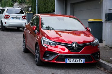 Mulhouse - Fransa - 19 Eylül 2024 - Caddeye park edilmiş kırmızı Renault Clio 'nun ön görüntüsü
