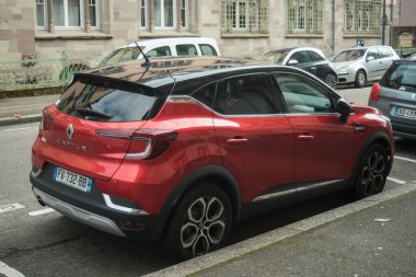 Mulhouse - Fransa - 2 Mart 2025 - Kırmızı Renault Captur 'un caddeye park edilmiş profili 