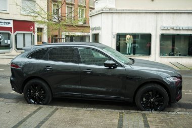 Mulhouse - Fransa - 29 Mart 2025 - Gri Jaguar SUV arabasının caddeye park edilmiş görüntüsü