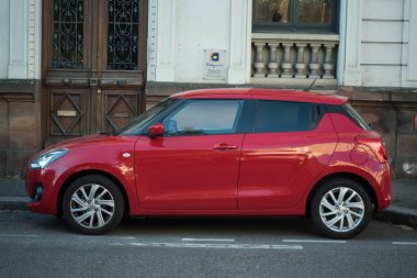Mulhouse - Fransa - 4 Nisan 2025 - sokağa park edilmiş kırmızı Suzuki Swift profili