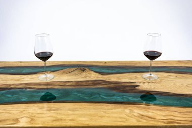 Kahve masası, oturma odası masası. Reçine el yapımı ahşap masa. Beyaz bir arka planda. Masada bir bardak viski. Masada bir kadeh şarap..