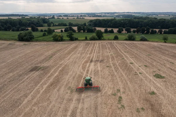 Harvesting field with combine in summer.  Harvest in the field, combine harvester mows grain in Nysa, Poland countryside.  Aerial drone photo of harvester.
