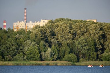 Endüstriyel çelik fabrikası, demir işi. Metalürjik bitki. Çelik fabrikası. Avrupa 'da ağır sanayi. Bacalardan gelen hava kirliliği. Mavi Göl 'ün arka planında demir işçiliği. Doğa ve endüstri.