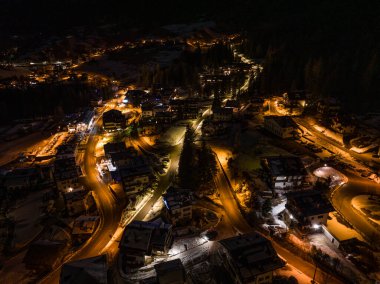 Civetta şehri gece drone görüntüsü. Dolomitlerde yeni yılda havai fişekler. Geceleri şehrin havadan görünüşü. Uzun pozlama fotoğrafı. Dolomitlerin Alplerinde Havai fişekler
