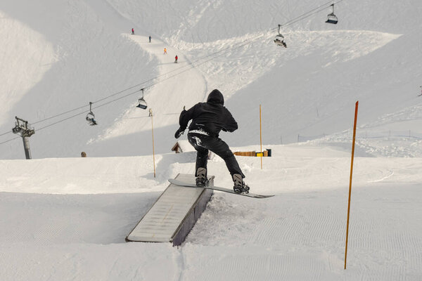 Snow park box tricks. Snowboarder in the park on a box. Winter jibbing in snwopark in France..