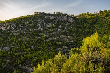 Zakynthos 'taki Damianos Mağarası günbatımı çam ağaçları, zeytin ağaçları ve Agalas perspektifinden Akdeniz batımına bakan bir Yunan adasında deniz manzarası. Yunanistan 'ın Zakynthos kentindeki yeşil alanlar ve ormanlar. 