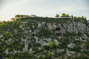 Zakynthos 'taki Damianos Mağarası günbatımı çam ağaçları, zeytin ağaçları ve Agalas perspektifinden Akdeniz batımına bakan bir Yunan adasında deniz manzarası. Yunanistan 'ın Zakynthos kentindeki yeşil alanlar ve ormanlar. 