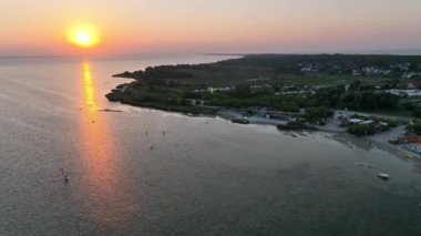 Hel penisula Jastarnia Puck Körfezi Baltık Denizi 'nde günbatımı manzarası. Gün batımında uçurtma. Gün batımında rüzgar sörfü. Gün batımında denizde su sporları.