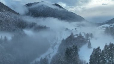 İtalyan Dolomitler 'deki Sisli Şehir' in insansız hava aracı görüntüsü. Alplerdeki İtalyan dağ kasabası Berguzzo. Dolomites Trentino 'daki Adamello Brenta Parkı. İtalyan dağlarında küçük bir kasabada bulutlu bir kış günü. Kışın sisli dağlar.