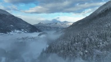 İtalyan Dolomitler 'deki Sisli Şehir' in insansız hava aracı görüntüsü. Alplerdeki İtalyan dağ kasabası Berguzzo. Dolomites Trentino 'daki Adamello Brenta Parkı. İtalyan dağlarında küçük bir kasabada bulutlu bir kış günü. Kışın sisli dağlar.