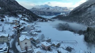 İtalyan Dolomitler 'deki Sisli Şehir' in insansız hava aracı görüntüsü. Alplerdeki İtalyan dağ kasabası Berguzzo. Dolomites Trentino 'daki Adamello Brenta Parkı. İtalyan dağlarında küçük bir kasabada bulutlu bir kış günü. Kışın sisli dağlar.