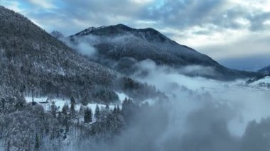 İtalyan Dolomitler 'deki Sisli Şehir' in insansız hava aracı görüntüsü. Alplerdeki İtalyan dağ kasabası Berguzzo. Dolomites Trentino 'daki Adamello Brenta Parkı. İtalyan dağlarında küçük bir kasabada bulutlu bir kış günü. Kışın sisli dağlar.