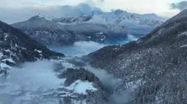 İtalyan Dolomitler 'deki Sisli Şehir' in insansız hava aracı görüntüsü. Alplerdeki İtalyan dağ kasabası Berguzzo. Dolomites Trentino 'daki Adamello Brenta Parkı. İtalyan dağlarında küçük bir kasabada bulutlu bir kış günü. Kışın sisli dağlar.