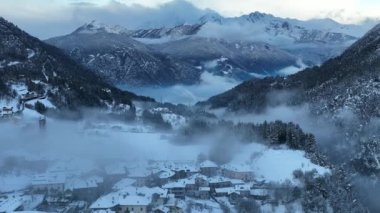 İtalyan Dolomitler 'deki Sisli Şehir' in insansız hava aracı görüntüsü. Alplerdeki İtalyan dağ kasabası Berguzzo. Dolomites Trentino 'daki Adamello Brenta Parkı. İtalyan dağlarında küçük bir kasabada bulutlu bir kış günü. Kışın sisli dağlar.