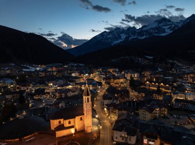 Geceleri Andalo şehrinin hava aracı görüntüsü ve kışın dağların arkası. Kayak merkezi Paganella Andalo, Trentino-Alto Adige, İtalya., İtalyan Dolomitleri, .Pagnella vadisi. Kışın kar İtalyan Dolomitlerini kapladı. 