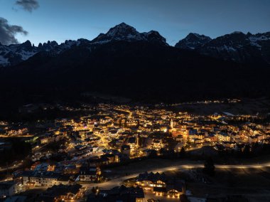 Geceleri Andalo şehrinin hava aracı görüntüsü ve kışın dağların arkası. Kayak merkezi Paganella Andalo, Trentino-Alto Adige, İtalya., İtalyan Dolomitleri, .Pagnella vadisi. Kışın kar İtalyan Dolomitlerini kapladı. 