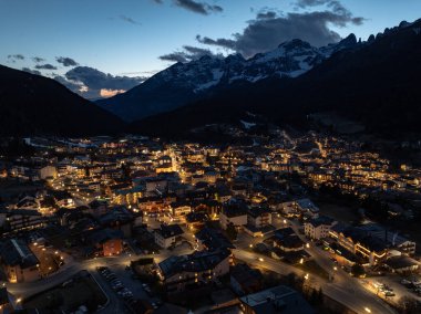 Geceleri Andalo şehrinin hava aracı görüntüsü ve kışın dağların arkası. Kayak merkezi Paganella Andalo, Trentino-Alto Adige, İtalya., İtalyan Dolomitleri, .Pagnella vadisi. Kışın kar İtalyan Dolomitlerini kapladı. 