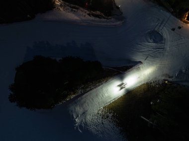 Geceleri Andalo şehrinin hava aracı görüntüsü ve kışın dağların arkası. Kayak merkezi Paganella Andalo, Trentino-Alto Adige, İtalya., İtalyan Dolomitleri, .Pagnella vadisi. Kışın kar İtalyan Dolomitlerini kapladı. 