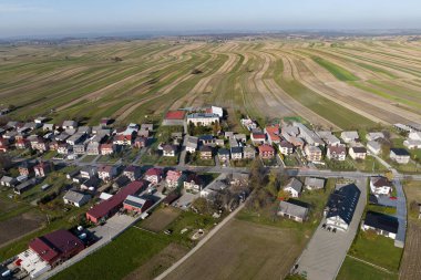 Polonya 'da evleri ve tarlaları olan güzel bir köy. İnsansız hava aracı görüş alanının ortasındaki köy. Küçük Polonya 'nın Krakow ilçesindeki Suloszowa köyü. Tarlalarda büyüyen tahılların hava aracı görüntüsü.