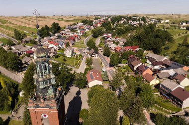 Polonya 'da evleri ve tarlaları olan güzel bir köy. İnsansız hava aracı görüş alanının ortasındaki köy. Küçük Polonya 'nın Krakow ilçesindeki Suloszowa köyü. Tarlalarda büyüyen tahılların hava aracı görüntüsü.