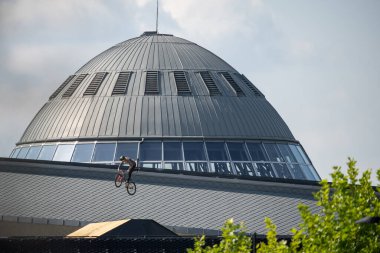 KATOWICE, POLAND - 21 AUGUST 2021: Bicycle Slopestyle World Cup. Red Bull Roof Ride Slopestyle competition in in International Conference Center in Katowice. Slopestyle big jumps, tricks in city.  clipart