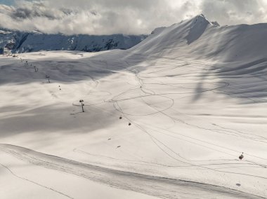 Kışın Gudauri kayak merkezinin insansız hava aracı görüntüsü. Gürcistan 'daki Kafkas Dağları. Kafkas kış dağlarında Kudebi, Bidara, Sadzele, Kobi hava manzarası.