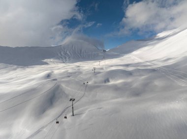 Kışın Gudauri kayak merkezinin insansız hava aracı görüntüsü. Gürcistan 'daki Kafkas Dağları. Kafkas kış dağlarında Kudebi, Bidara, Sadzele, Kobi hava manzarası.