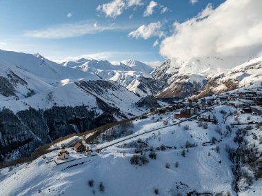 Gudauri, Georgia 'daki Amaglebis eklesia kilisesinin hava aracı görüntüsü. Kafkasya 'daki Ortodoks kilise mimarisi. Kışın Gudauri kayak merkezi. Gürcistan 'daki Kafkas Dağları