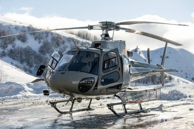 Helicopter in the mountains. freeride heliboarding in the Caucasus. Helicopter is standing on a landing field in the mountains.  clipart