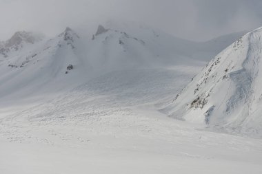 Kar tozu üzerinde freeride rali izleri. Kudebi, Bidara, Sadzele, Kafkas kış dağlarındaki Kobi hava manzarası. Kışın Gudauri kayak merkezinin insansız hava aracı görüntüsü. Gürcistan 'daki Kafkas Dağları