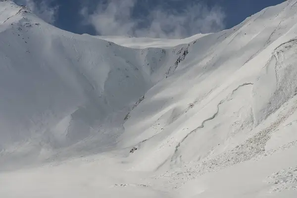 Snow avalanche in the mountains. Kudebi, Bidara, Sadzele, Kobi aerial panorama in caucasus winter mountains. Aerial drone view of Gudauri ski resort in winter. Caucasus mountains in Georgia