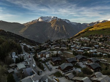 Hava aracı fotoğrafı. Kışın Fransız Alpleri, Fransa 'da Rhone Alpes Avrupa. İlkbahar zamanı Les Deux Alpes Köyü. Gün batımında Alp dağlarında bir kasaba. Fransız Alpleri 'nin kış kasabası.