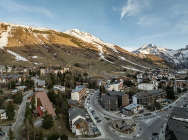 Hava aracı fotoğrafı. Kışın Fransız Alpleri, Fransa 'da Rhone Alpes Avrupa. İlkbahar zamanı Les Deux Alpes Köyü. Gün batımında Alp dağlarında bir kasaba. Fransız Alpleri 'nin kış kasabası.