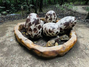 Dinosaur eggs. Realistic figure of an eggs dinosaur inforest park in Kazimierz Sosnowiec. Prehistoric predator create a fascinating element of the landscape, attracting dinosaur lovers. clipart