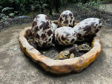 Dinosaur eggs. Realistic figure of an eggs dinosaur inforest park in Kazimierz Sosnowiec. Prehistoric predator create a fascinating element of the landscape, attracting dinosaur lovers. clipart