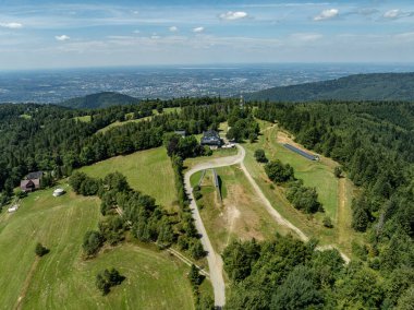 Beskids, Bielsko Biala, Magurka Wilkowicka 'daki yeşil ormanların çarpıcı hava aracı görüntüsü. Magurka Wilkowicka 'da bir barınak. Tepelerin manzarası yemyeşil yeşilliğin güzelliğini ve huzurunu yansıtır.. 