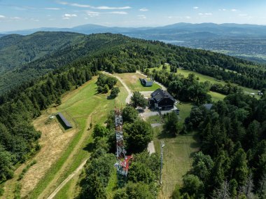 Beskids, Bielsko Biala, Magurka Wilkowicka 'daki yeşil ormanların çarpıcı hava aracı görüntüsü. Magurka Wilkowicka 'da bir barınak. Tepelerin manzarası yemyeşil yeşilliğin güzelliğini ve huzurunu yansıtır.. 