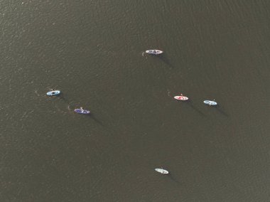 Gölde yüzen insanların insansız hava aracı görüntüsü. Gölde Dik Kürek. Göldeki panolarda bir sürü insan var..