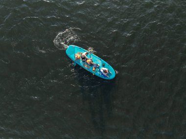 Gölde yüzen insanların insansız hava aracı görüntüsü. Gölde Dik Kürek. Göldeki panolarda bir sürü insan var..