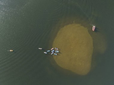 Gölde yüzen insanların insansız hava aracı görüntüsü. Gölde Dik Kürek. Göldeki panolarda bir sürü insan var..