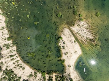 Orman bir göle battı. Polonya 'nın Klucze şehrinde kristal berrak su birikintisi. Sel basmış kum çukurunun hava aracı görüntüsü. Sel basmış bir kum çukurundan sonra yapay bir göl.. 